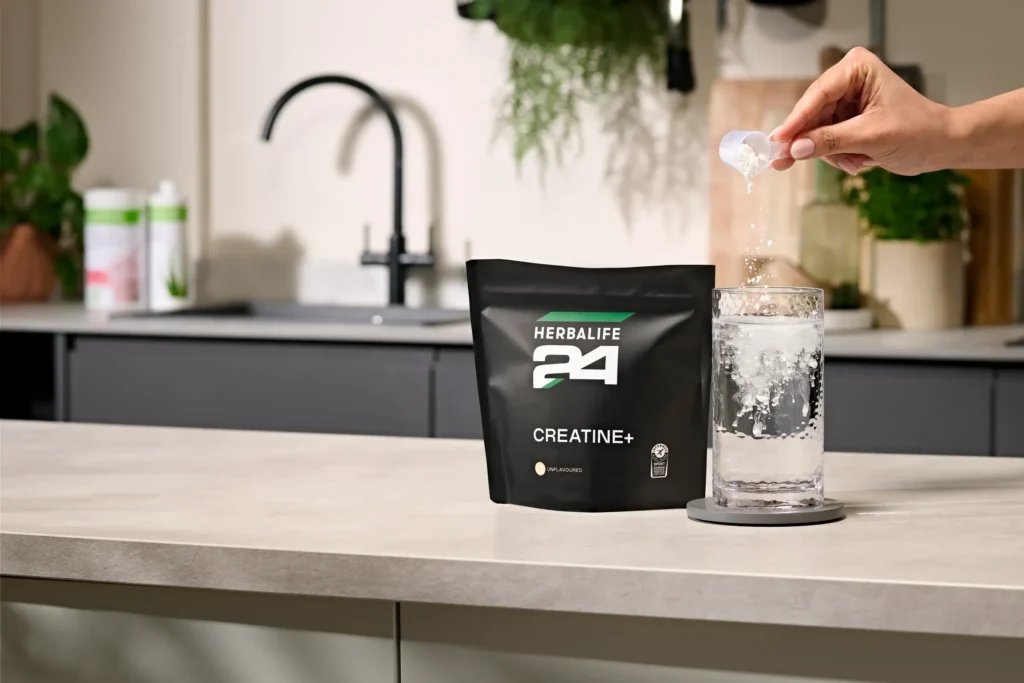 creatine sachets with a glass of water having creatine powder poured in