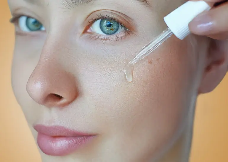 A close up image of a woman doing her skin care using the Herbalife nutrition niacinamide serum